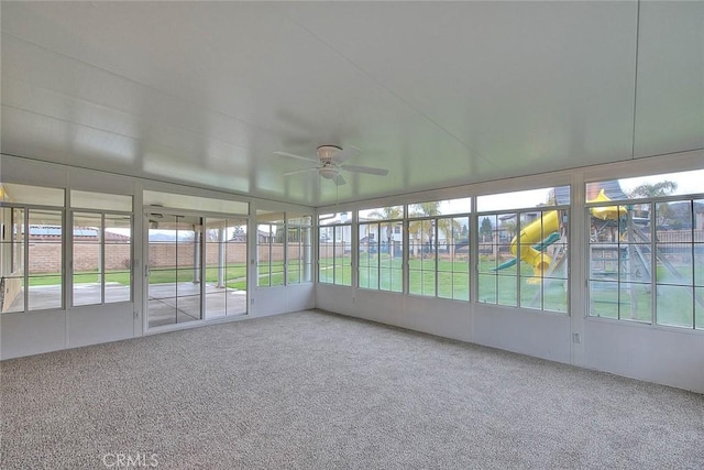 unfurnished sunroom featuring a ceiling fan