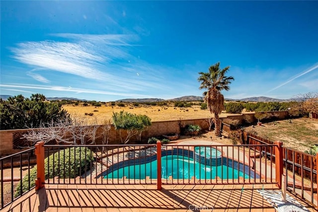 view of swimming pool with a patio area, a fenced backyard, a mountain view, and a pool with connected hot tub