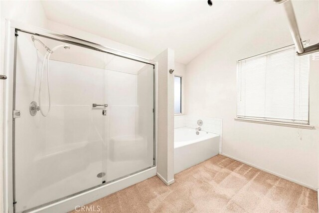 bathroom featuring a bath, a shower stall, and vaulted ceiling