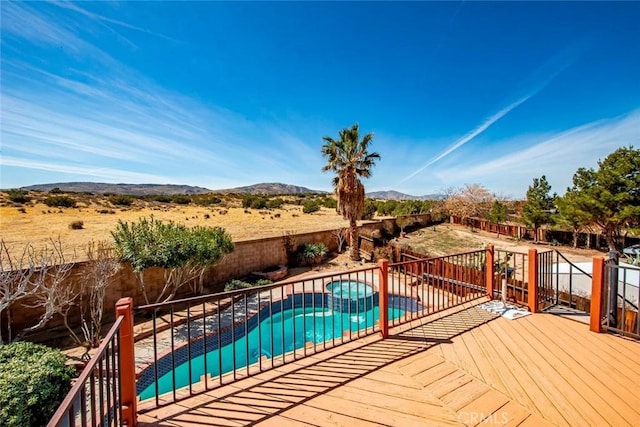 view of pool with a mountain view, a pool with connected hot tub, a fenced backyard, and a patio