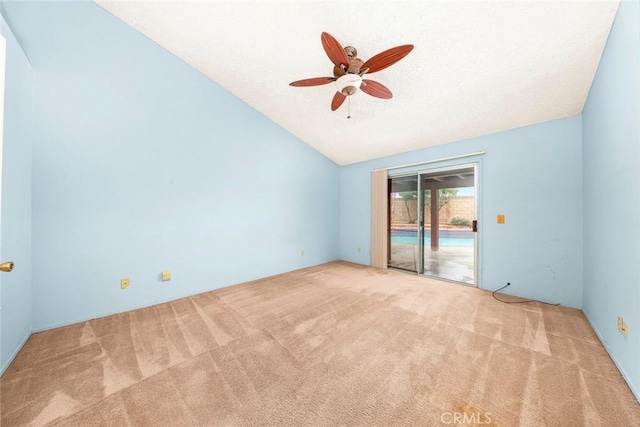 spare room featuring a ceiling fan, lofted ceiling, and carpet