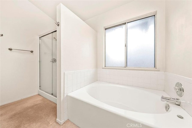 full bathroom featuring a bath and a stall shower