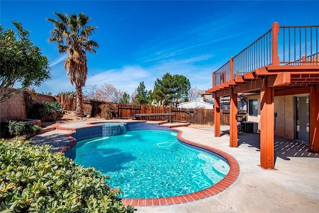 view of swimming pool featuring a pool with connected hot tub, central air condition unit, a patio area, and a fenced backyard