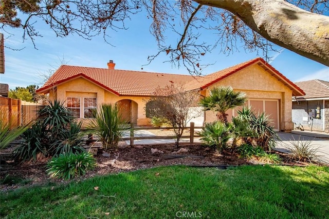 view of front facade with stucco siding, a tile roof, concrete driveway, an attached garage, and a chimney