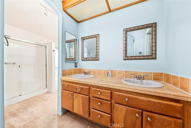 full bath with double vanity, a stall shower, and a sink