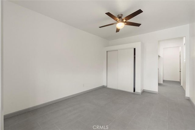 unfurnished bedroom featuring a closet, ceiling fan, and baseboards