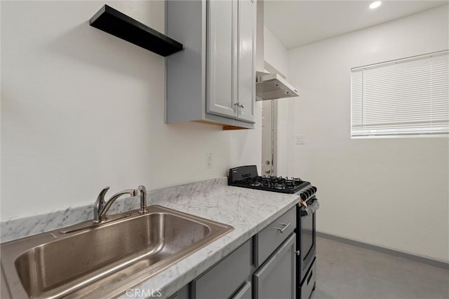 kitchen featuring stainless steel gas range oven, gray cabinetry, under cabinet range hood, recessed lighting, and a sink