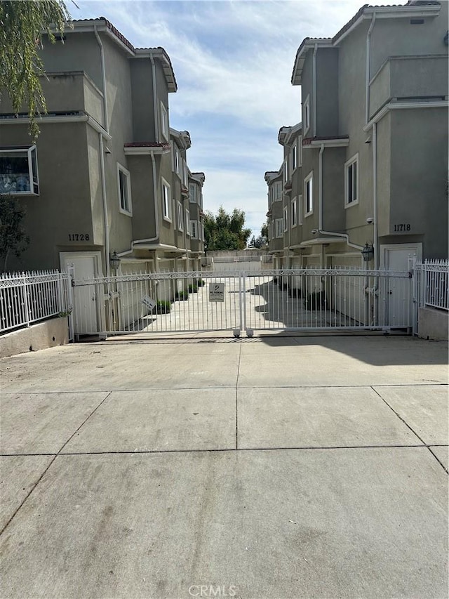 view of street featuring a residential view and a gate