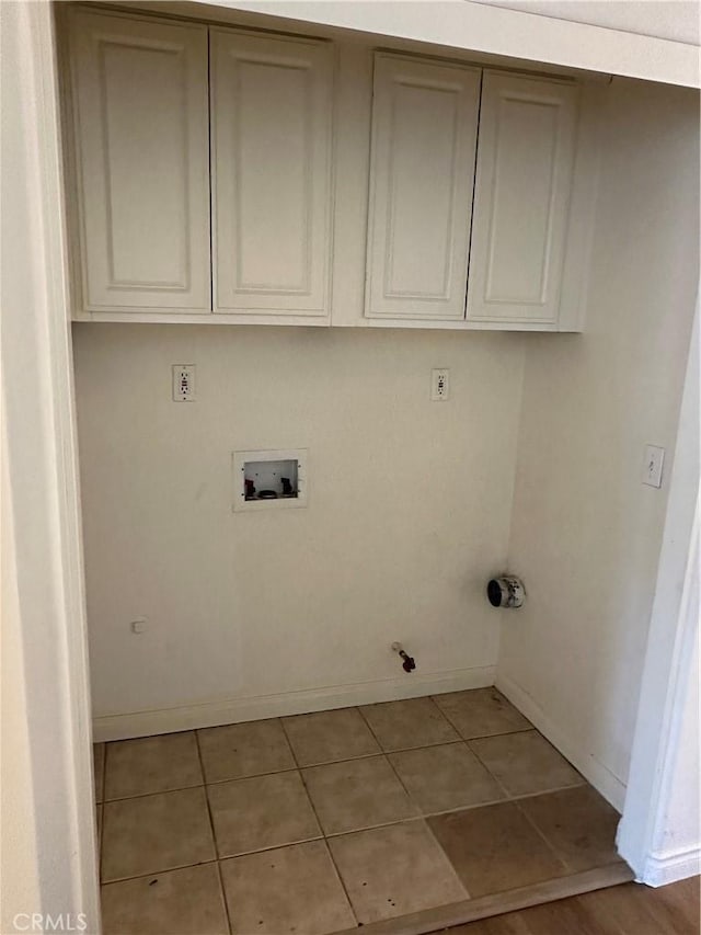 laundry area featuring light tile patterned floors, hookup for a gas dryer, cabinet space, and washer hookup