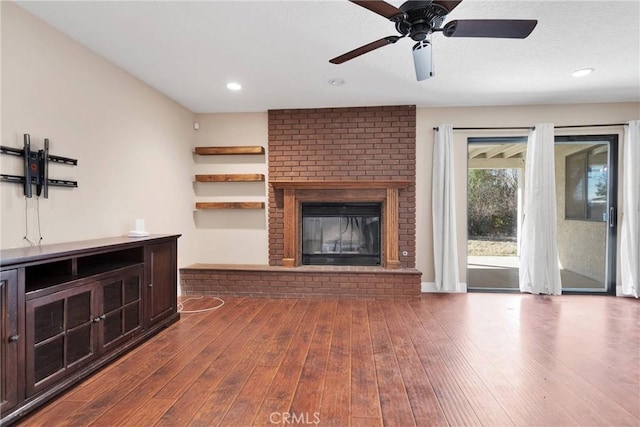 unfurnished living room featuring a fireplace, recessed lighting, and dark wood-style floors