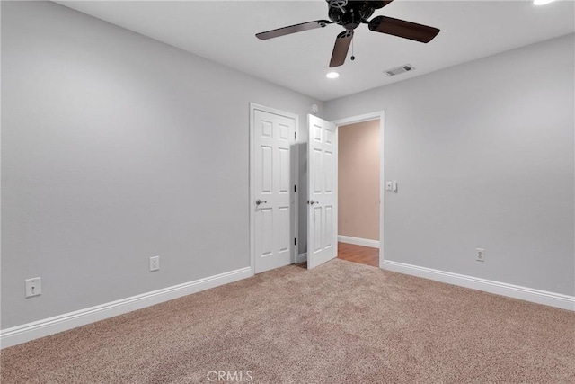 unfurnished bedroom featuring visible vents, light carpet, baseboards, and a ceiling fan