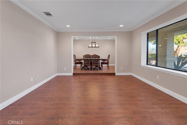 empty room with visible vents, baseboards, dark wood-style floors, and crown molding