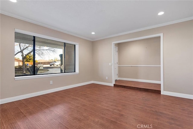 unfurnished room featuring crown molding, wood finished floors, and baseboards