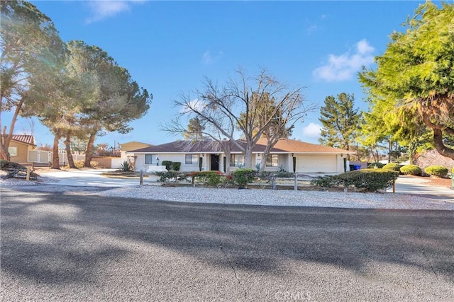 ranch-style home with concrete driveway and an attached garage