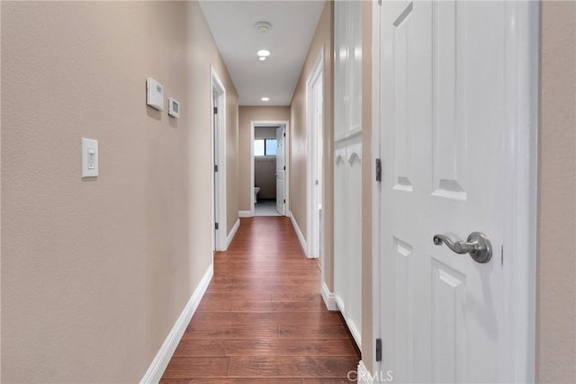 hall with baseboards and dark wood-style floors