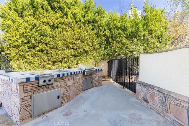 view of patio with area for grilling and fence