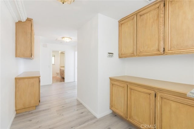 hallway with light wood-style floors and baseboards