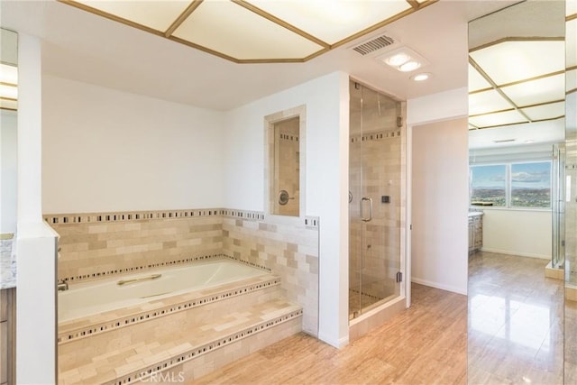 bathroom with a bath, visible vents, a shower stall, and baseboards