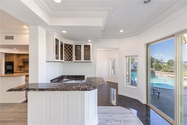 kitchen with visible vents, ornamental molding, dark stone countertops, recessed lighting, and baseboards