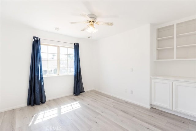 unfurnished room featuring light wood-style flooring, baseboards, and ceiling fan