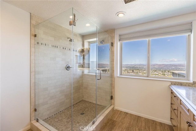 bathroom featuring a shower stall, vanity, baseboards, and wood finished floors