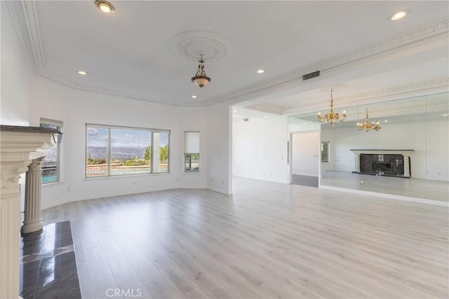 unfurnished living room with visible vents, wood finished floors, crown molding, a premium fireplace, and baseboards