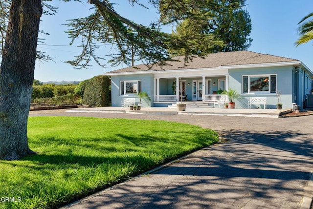 single story home with covered porch, stucco siding, a front lawn, and central AC unit