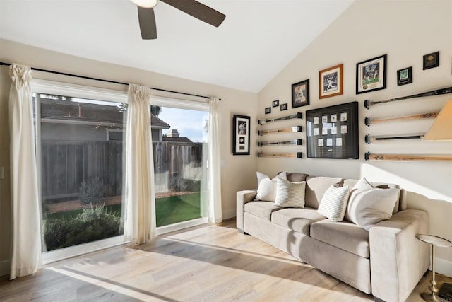 living area with ceiling fan, wood finished floors, and vaulted ceiling