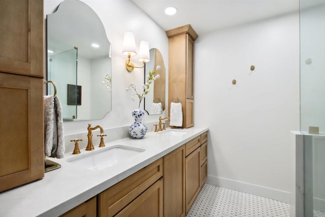 full bath featuring a sink, baseboards, recessed lighting, and double vanity