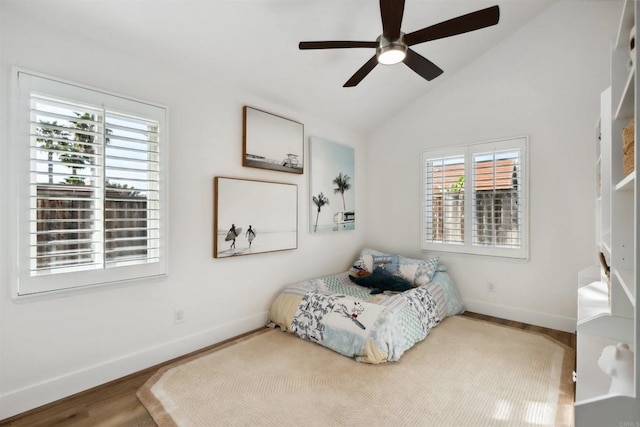 bedroom with baseboards, a ceiling fan, lofted ceiling, and wood finished floors