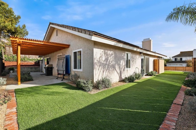 view of home's exterior with stucco siding, a chimney, a yard, a patio area, and a pergola