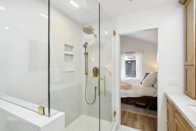 ensuite bathroom with an enclosed shower, wood finished floors, and ensuite bathroom