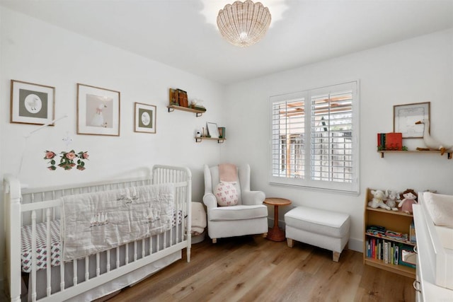 bedroom featuring a crib and wood finished floors