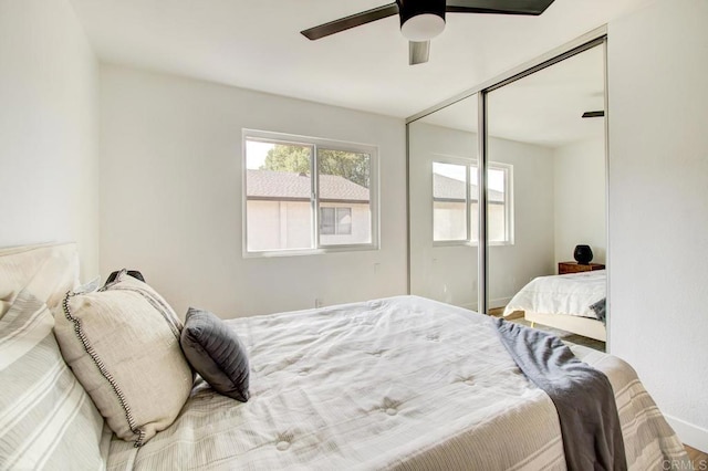 bedroom with multiple windows, a ceiling fan, and a closet