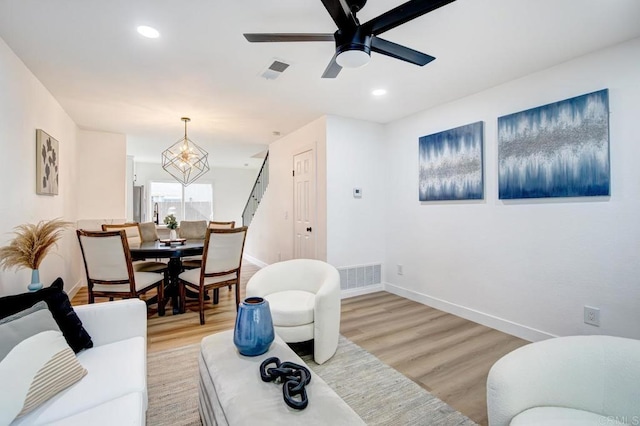 living area with baseboards, visible vents, and light wood-type flooring