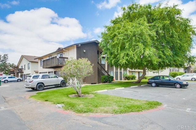 view of front of home featuring a front yard and uncovered parking