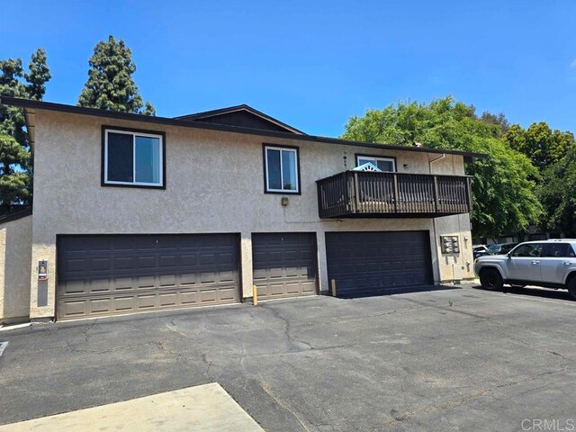 view of front of home featuring a balcony, stucco siding, and a garage