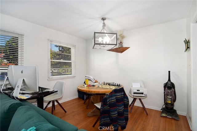 home office featuring a notable chandelier, baseboards, and wood finished floors