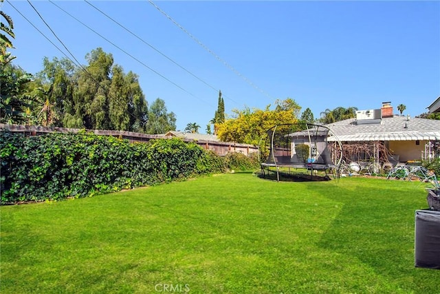 view of yard with a fenced backyard and a trampoline