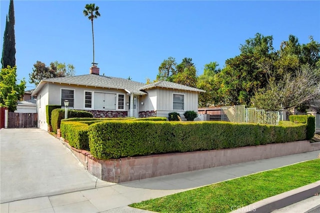 ranch-style house featuring a chimney and fence