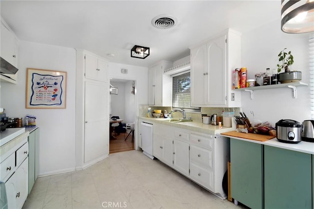 kitchen with white cabinets, light countertops, and a sink