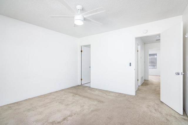 empty room featuring light carpet, a textured ceiling, and ceiling fan