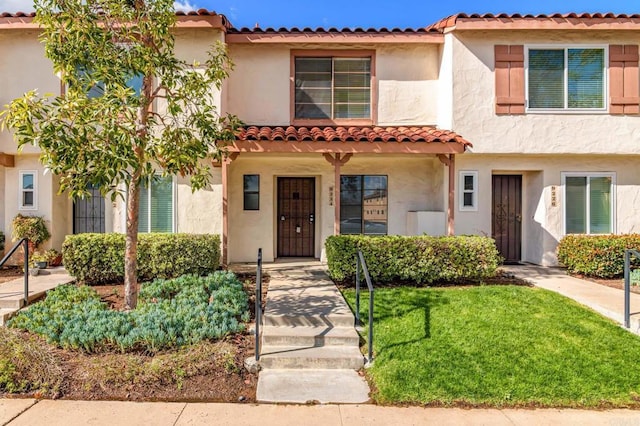 view of front of home featuring stucco siding and a front lawn