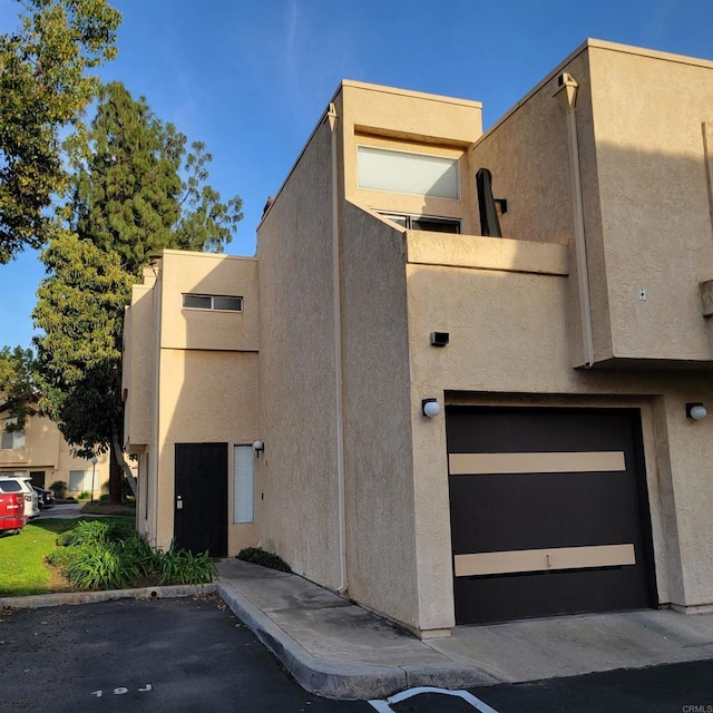 view of front facade with stucco siding and an attached garage