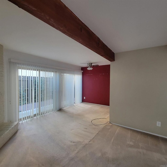 carpeted empty room featuring beamed ceiling, baseboards, and a ceiling fan