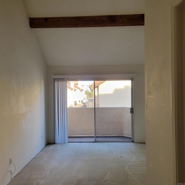 unfurnished room featuring carpet flooring and vaulted ceiling with beams