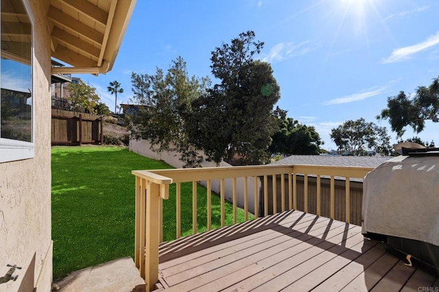 wooden terrace featuring a lawn and fence