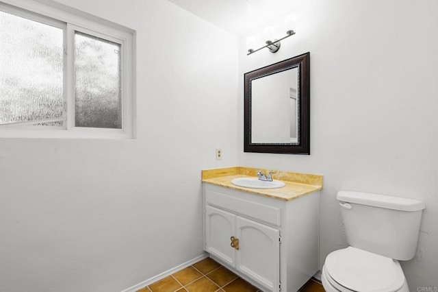 half bathroom with tile patterned flooring, toilet, vanity, and baseboards