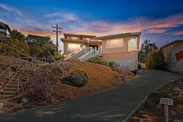 mediterranean / spanish house with stairway, a garage, and stucco siding