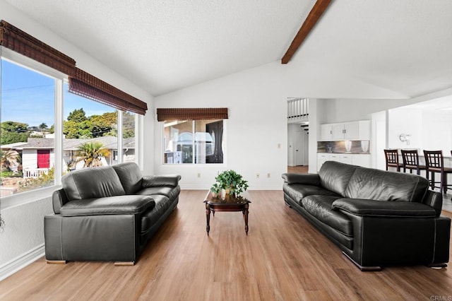 living room featuring baseboards, light wood-style floors, and vaulted ceiling with beams